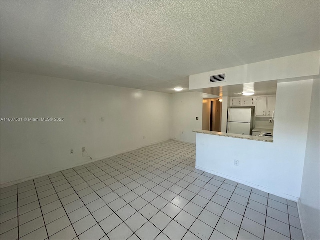 8670 NW 6th Ln Unit 4-103, Miami, FL 33126 - unfurnished living room featuring a textured ceiling and light tile patterned floors