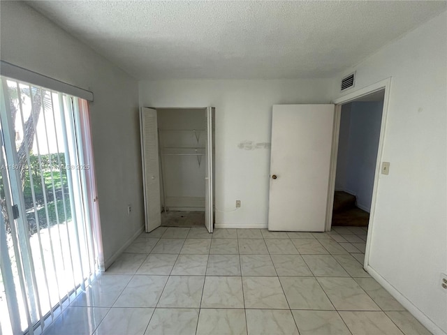 8670 NW 6th Ln Unit 4-103, Miami, FL 33126 - unfurnished bedroom with a textured ceiling, a closet, and baseboards