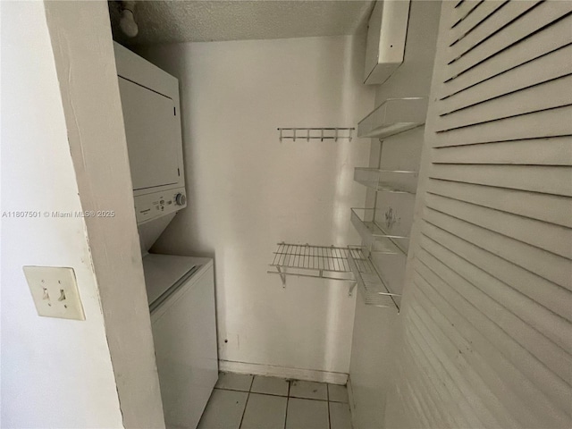 8670 NW 6th Ln Unit 4-103, Miami, FL 33126 - laundry area with tile patterned floors, stacked washer and clothes dryer, and a textured ceiling