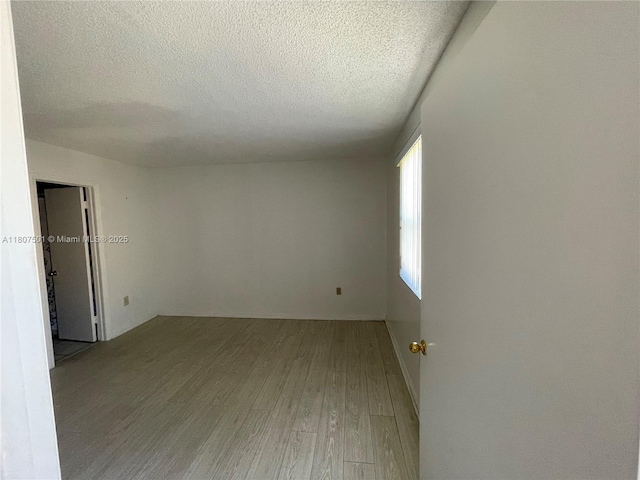 8670 NW 6th Ln Unit 4-103, Miami, FL 33126 - spare room featuring wood finished floors and a textured ceiling
