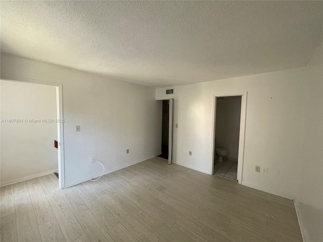 8670 NW 6th Ln Unit 4-103, Miami, FL 33126 - empty room featuring light wood-style flooring and a textured ceiling