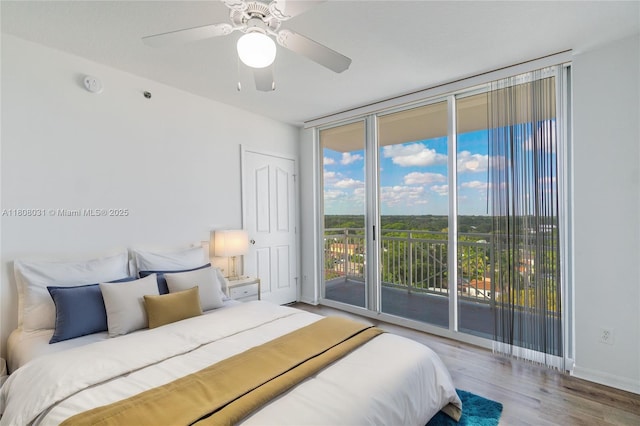 2665 SW 37th Ave Unit 906, Miami, FL 33133 - bedroom featuring access to exterior, wood finished floors, a wall of windows, a ceiling fan, and baseboards