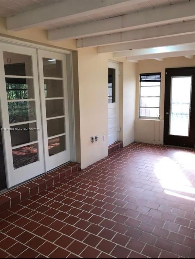 1745 NW 47th St, Miami, FL 33142 - empty room featuring beamed ceiling, brick patterned flooring, and french doors