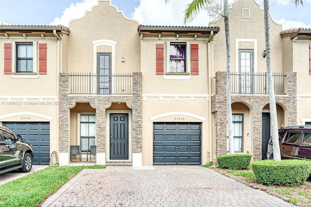 23558 SW 113th Psge, Homestead, FL 33032 - view of property featuring a balcony, a garage, decorative driveway, and stone siding