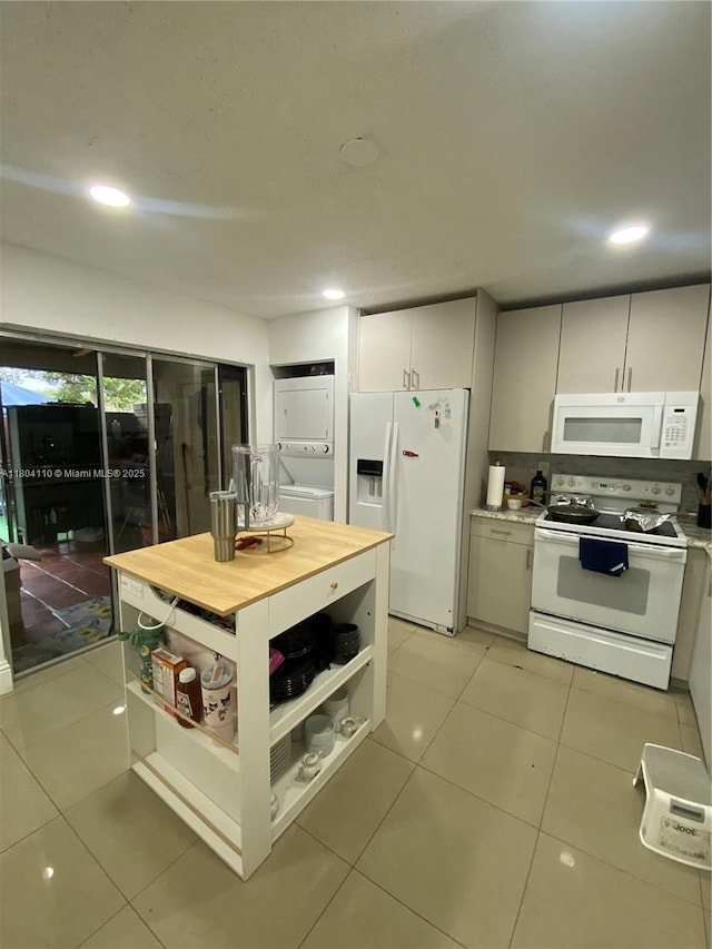 450 NW 46th St Unit 450, Deerfield Beach, FL 33064 - kitchen with stacked washer / drying machine, white appliances, light tile patterned floors, open shelves, and recessed lighting