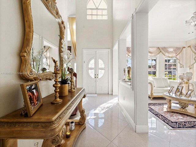 11230 SW 156th Ave, Miami, FL 33196 - entrance foyer with light tile patterned floors, a towering ceiling, baseboards, and crown molding