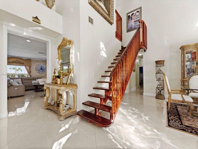 11230 SW 156th Ave, Miami, FL 33196 - stairway with a high ceiling, marble tiled flooring, and baseboards