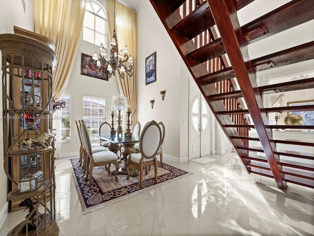 11230 SW 156th Ave, Miami, FL 33196 - dining area featuring baseboards, stairs, a chandelier, marble tiled flooring, and a towering ceiling