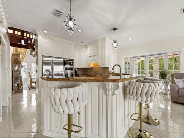 11230 SW 156th Ave, Miami, FL 33196 - kitchen featuring appliances with stainless steel finishes, a chandelier, decorative backsplash, crown molding, and a breakfast bar area