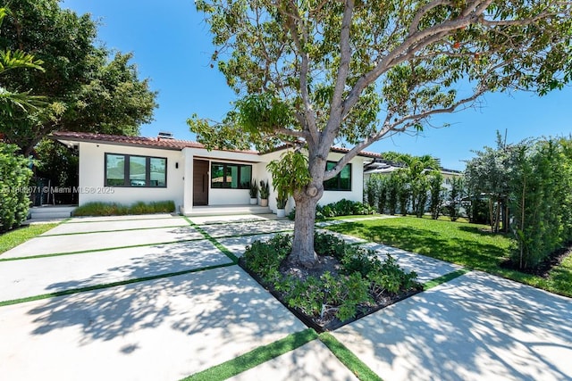 8959 Abbott Ave, Surfside, FL 33154 - mediterranean / spanish home featuring stucco siding, a front yard, driveway, and a tiled roof