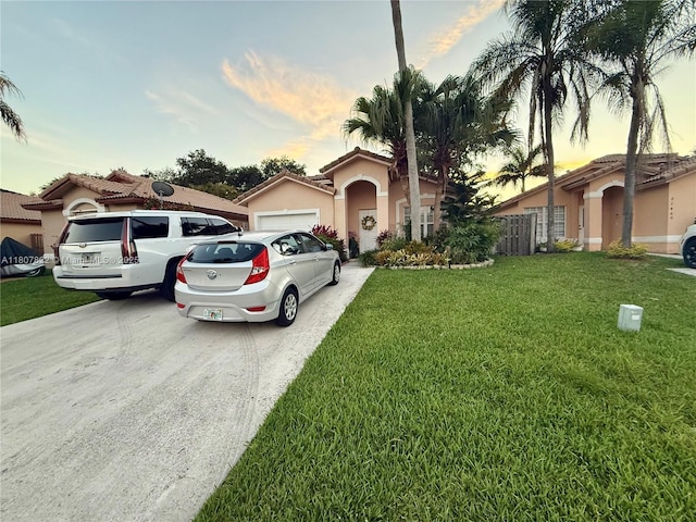 21468 SW 88th Ave, Cutler Bay, FL 33189 - mediterranean / spanish-style home with a yard, stucco siding, concrete driveway, an attached garage, and a tile roof