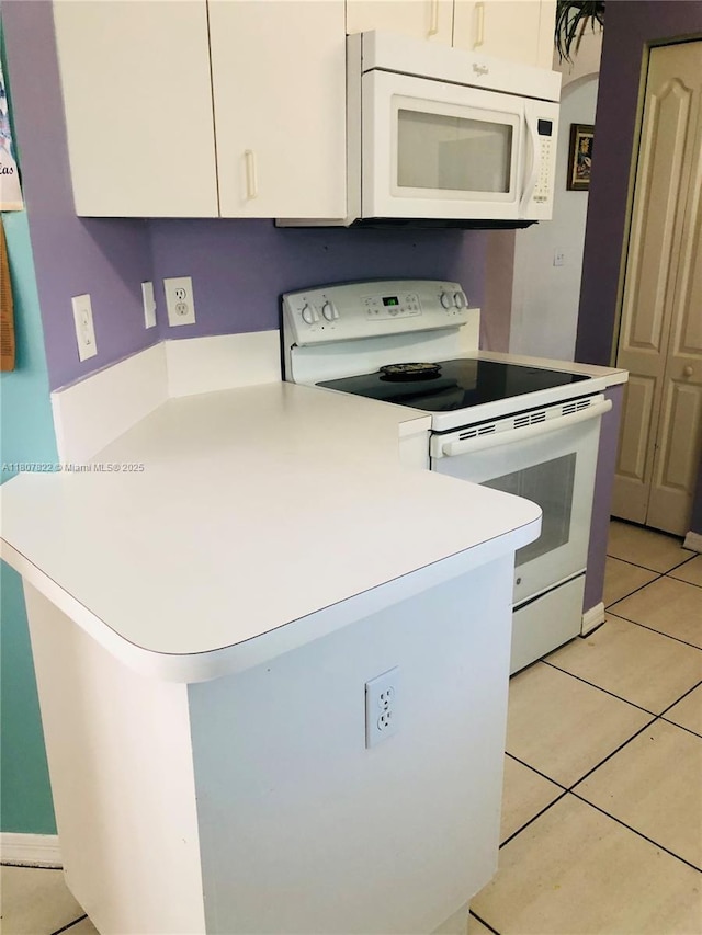21468 SW 88th Ave, Cutler Bay, FL 33189 - kitchen with white appliances, white cabinets, light countertops, a peninsula, and light tile patterned floors