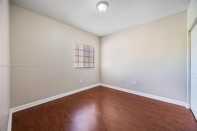 1880 SE 3rd Dr, Homestead, FL 33033 - spare room featuring baseboards and dark wood-style floors