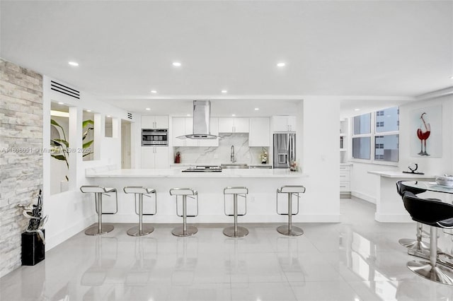 2751 S Ocean Dr Unit 301S, Hollywood, FL 33019 - kitchen with island range hood, appliances with stainless steel finishes, a breakfast bar, white cabinets, and a sink