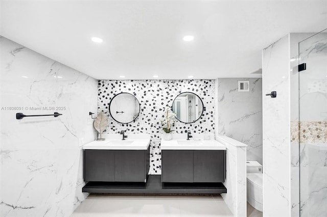 2751 S Ocean Dr Unit 301S, Hollywood, FL 33019 - bathroom featuring two vanities, tile walls, a marble finish shower, recessed lighting, and toilet