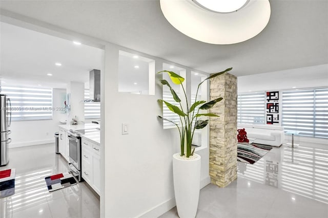 2751 S Ocean Dr Unit 301S, Hollywood, FL 33019 - kitchen featuring stainless steel appliances, wall chimney range hood, white cabinets, and baseboards