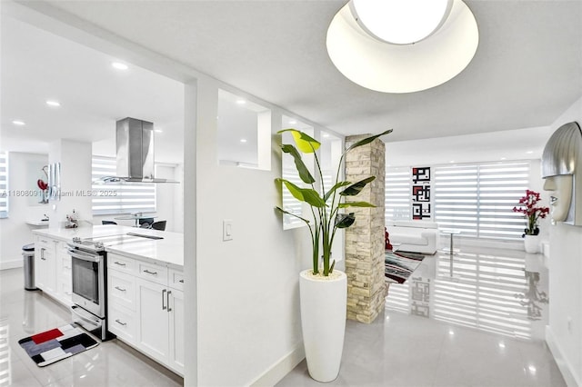 2751 S Ocean Dr Unit 301S, Hollywood, FL 33019 - kitchen with island exhaust hood, stainless steel electric range, baseboards, white cabinets, and light stone countertops