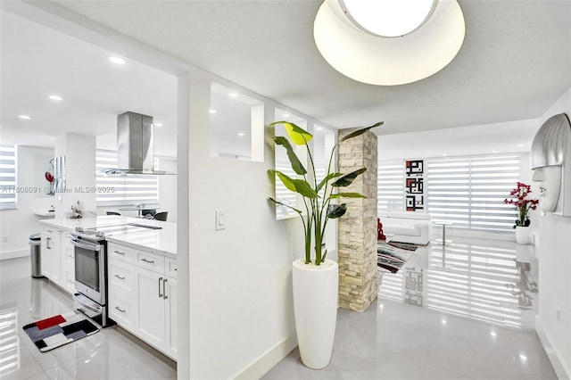 2751 S Ocean Dr Unit 301S, Hollywood, FL 33019 - kitchen with stainless steel electric range, island exhaust hood, baseboards, white cabinetry, and light stone counters