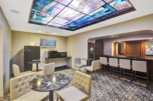 2751 S Ocean Dr Unit 301S, Hollywood, FL 33019 - dining room featuring arched walkways, a raised ceiling, and baseboards