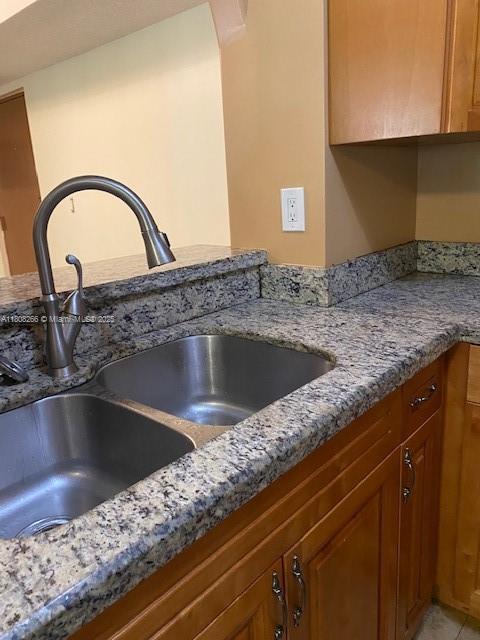 8004 SW 149th Ave Unit C102, Miami, FL 33193 - kitchen view of a sink, light stone counters, and brown cabinets