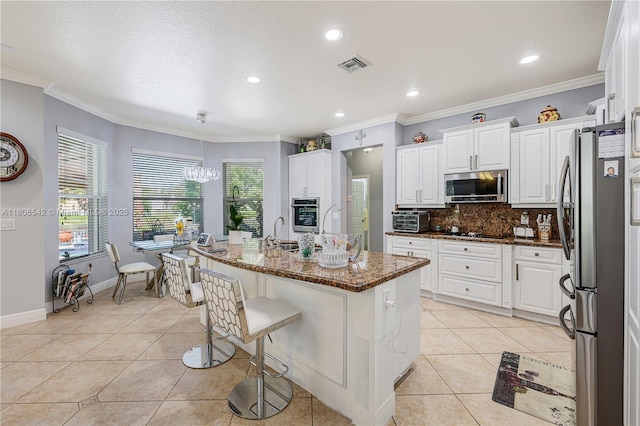 4604 SW 132nd Ave, Miramar, FL 33027 - kitchen with stainless steel appliances, decorative backsplash, light tile patterned floors, white cabinets, and ornamental molding