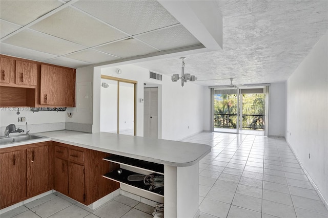 7100 NW 17th St Unit 306, Plantation, FL 33313 - kitchen with a sink, open floor plan, light countertops, a peninsula, and light tile patterned floors