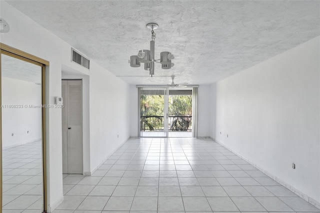 7100 NW 17th St Unit 306, Plantation, FL 33313 - unfurnished room with light tile patterned flooring, a chandelier, a ceiling fan, baseboards, and a textured ceiling