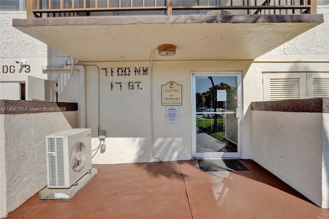 7100 NW 17th St Unit 306, Plantation, FL 33313 - view of exterior entry featuring a cooling unit and stucco siding