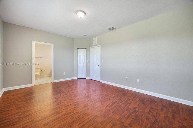 1985 SE 3rd St, Homestead, FL 33033 - unfurnished bedroom with baseboards, wood finished floors, and connected bathroom