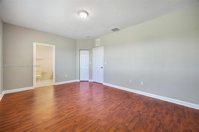 1985 SE 3rd St, Homestead, FL 33033 - unfurnished bedroom with baseboards, wood finished floors, and connected bathroom