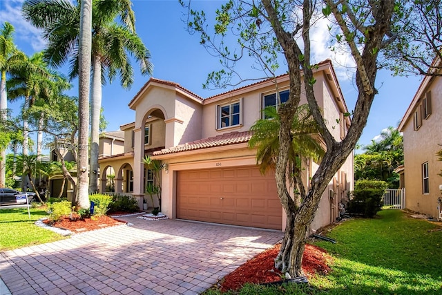 850 Nandina Dr, Weston, FL 33327 - mediterranean / spanish house featuring stucco siding, a garage, a tiled roof, a front yard, and decorative driveway