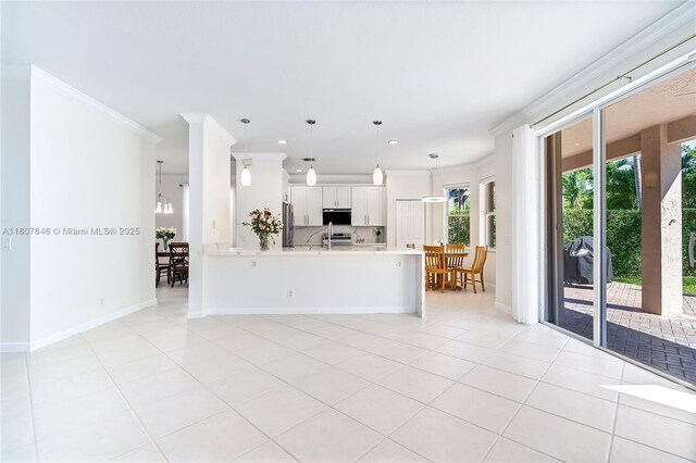850 Nandina Dr, Weston, FL 33327 - kitchen with light countertops, crown molding, a peninsula, stainless steel refrigerator, and light tile patterned flooring