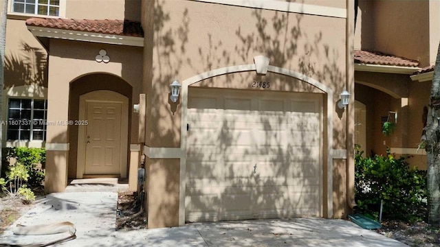 21485 SW 85th Path, Cutler Bay, FL 33189 - view of exterior entry featuring stucco siding, a tile roof, and driveway