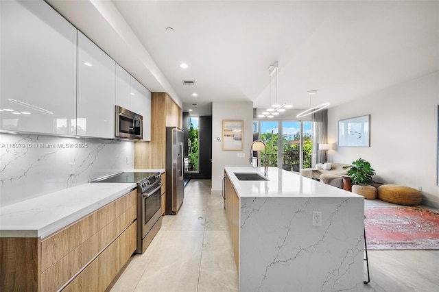 529 SW 11th St Unit 201, Miami, FL 33129 - kitchen featuring modern cabinets, appliances with stainless steel finishes, a sink, decorative backsplash, and open floor plan