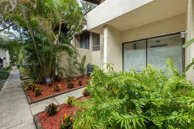 19460 NE 26th Ave Unit 12B, Miami, FL 33180 - view of exterior entry featuring stucco siding and cooling unit