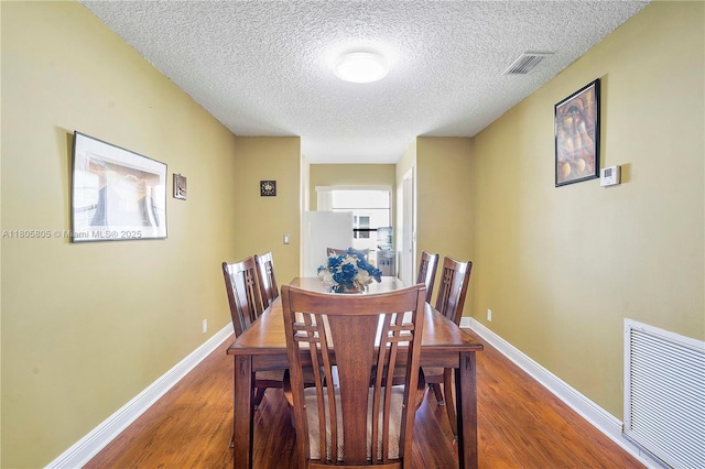 11186 NW 21st St, Coral Springs, FL 33071 - dining space featuring wood finished floors, a textured ceiling, and baseboards