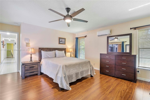 11186 NW 21st St, Coral Springs, FL 33071 - bedroom with a wall mounted AC, wood finished floors, baseboards, a textured ceiling, and a ceiling fan