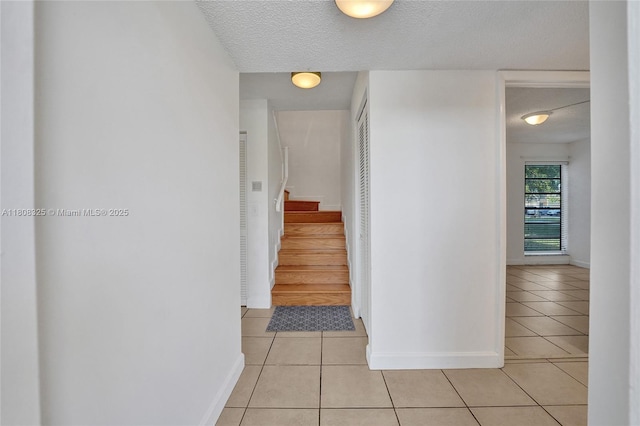 1551 NW 92nd Ave Unit 185, Pembroke Pines, FL 33024 - corridor featuring light tile patterned floors, baseboards, stairway, and a textured ceiling