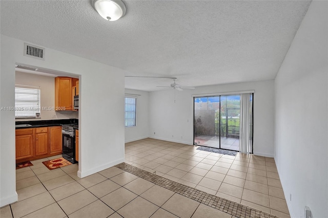 1551 NW 92nd Ave Unit 185, Pembroke Pines, FL 33024 - unfurnished room featuring healthy amount of natural light, a textured ceiling, a ceiling fan, light tile patterned floors, and baseboards