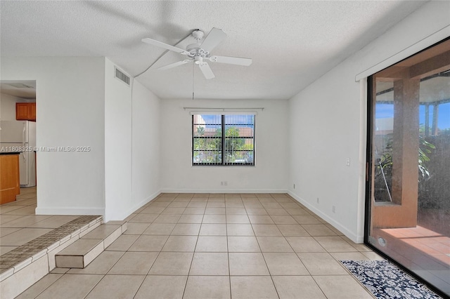 1551 NW 92nd Ave Unit 185, Pembroke Pines, FL 33024 - spare room featuring a textured ceiling, light tile patterned floors, a ceiling fan, and baseboards