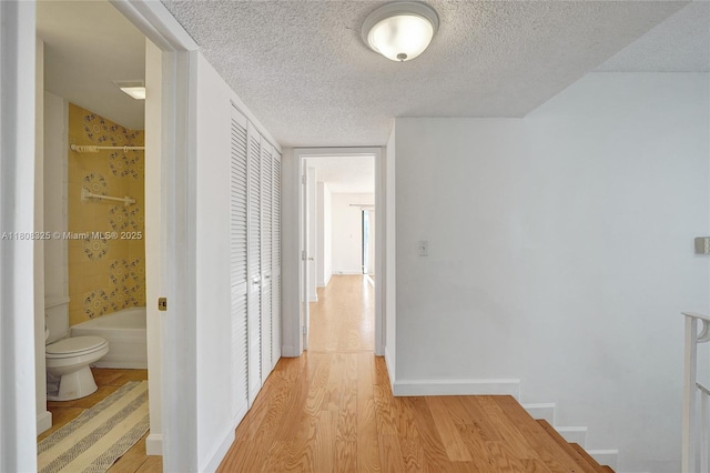 1551 NW 92nd Ave Unit 185, Pembroke Pines, FL 33024 - hall with light wood-style flooring, a textured ceiling, and baseboards