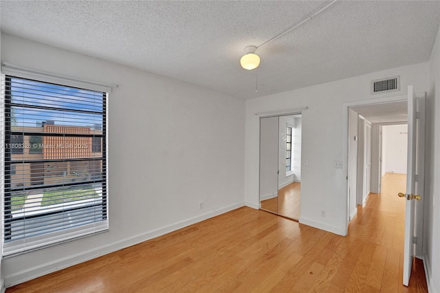 1551 NW 92nd Ave Unit 185, Pembroke Pines, FL 33024 - spare room featuring light wood finished floors, healthy amount of natural light, a textured ceiling, and baseboards