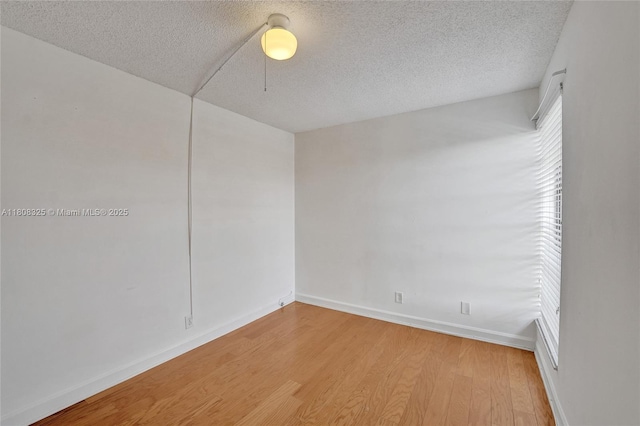 1551 NW 92nd Ave Unit 185, Pembroke Pines, FL 33024 - spare room with wood finished floors, a textured ceiling, and baseboards