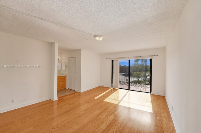1551 NW 92nd Ave Unit 185, Pembroke Pines, FL 33024 - empty room with a textured ceiling, light wood finished floors, and baseboards