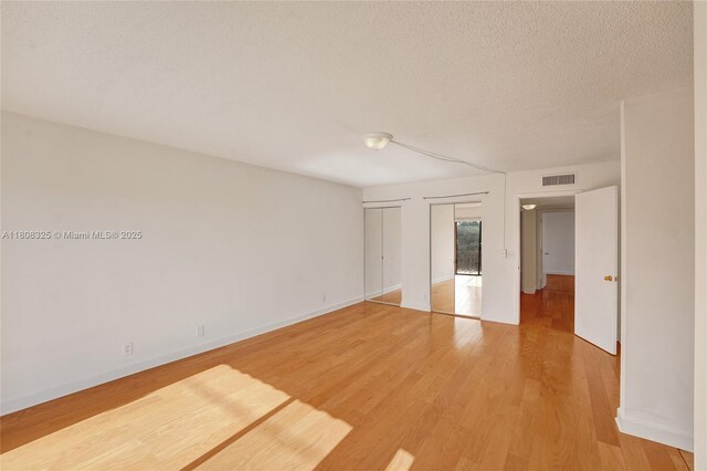 1551 NW 92nd Ave Unit 185, Pembroke Pines, FL 33024 - spare room with light wood-style flooring, a textured ceiling, and baseboards
