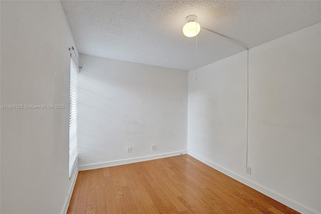 1551 NW 92nd Ave Unit 185, Pembroke Pines, FL 33024 - spare room with wood finished floors, a textured ceiling, and baseboards