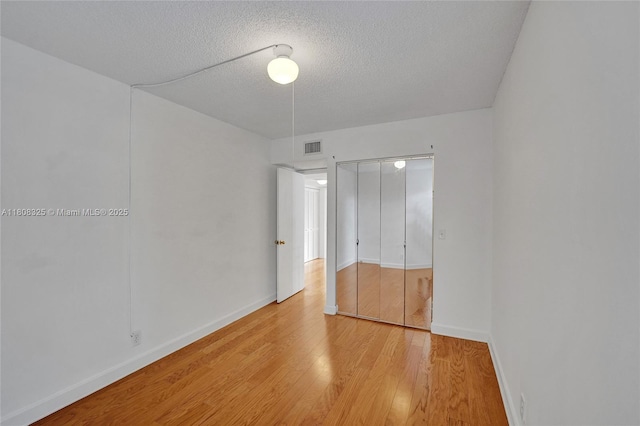 1551 NW 92nd Ave Unit 185, Pembroke Pines, FL 33024 - unfurnished bedroom with a textured ceiling, a closet, light wood-style flooring, and baseboards