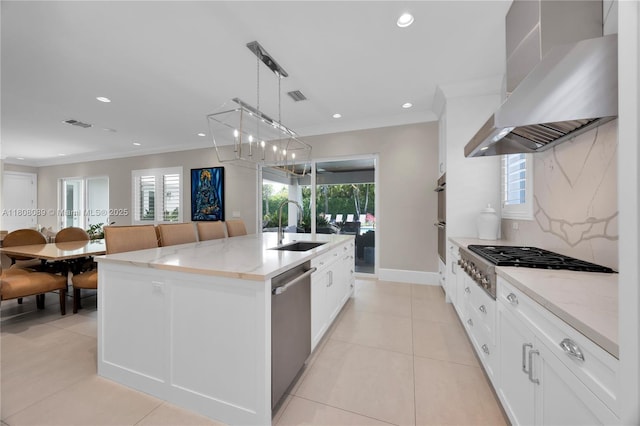 7495 SW 105th Ter, Pinecrest, FL 33156 - kitchen featuring wall chimney range hood, appliances with stainless steel finishes, a sink, an island with sink, and tasteful backsplash