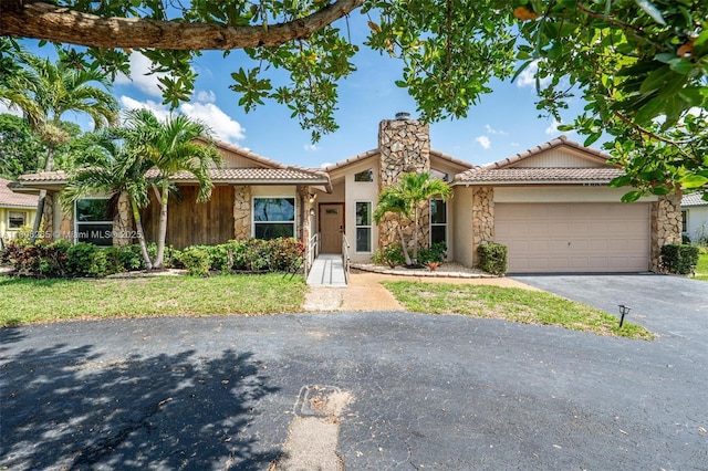 9919 SW 1st Ct, Coral Springs, FL 33071 - view of front facade featuring stone siding, asphalt driveway, a tile roof, and a garage