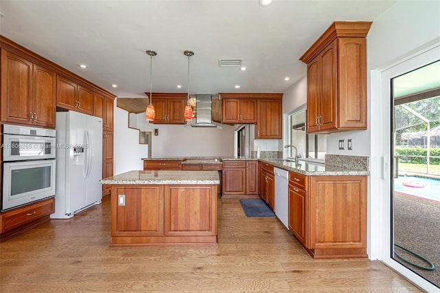 9919 SW 1st Ct, Coral Springs, FL 33071 - kitchen featuring white appliances, wall chimney exhaust hood, light stone countertops, brown cabinets, and recessed lighting